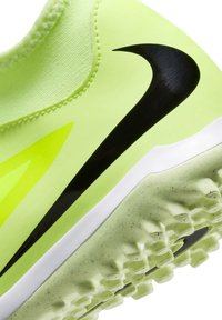 Sneaker giallo neon con logo nero, suola testurizzata e parte superiore liscia in materiale stratificato, accompagnata da una suola intermedia bianca.