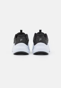 Baskets de sport noires avec un dessus texturé, une languette proéminente et une semelle intermédiaire blanche. Comprend une semelle extérieure en caoutchouc noir et un détail de logo subtil.