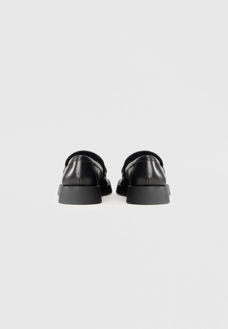 Schwarze Lederschuhe mit einer runden Spitze und flacher Gummisohle. Die Rückseite hat eine glatte Kontur und keine sichtbaren Beschläge.