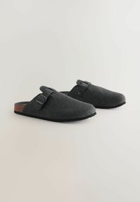Grau gefütterte Clogs zum Hineinschlüpfen mit einem Korkakzent an der Ferse, ausgestattet mit einem verstellbaren Riemen und einer strukturierten Gummi-Sohle.