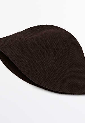 Mørkebrun tekstureret strikket bøllehat lagt fladt på en hvid overflade med synligt vævet mønster.