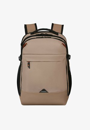 Tan fabric backpack with black accents, multiple zippers, and a front pocket. Features padded shoulder straps and a textured surface.