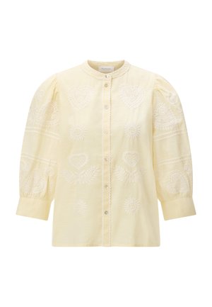 Lichtgele blouse met geplooide lange mouwen, delicate witte geborduurde harten en zonmotieven, en een knoopsluiting aan de voorkant.