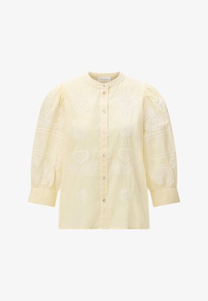 Lichtgele blouse met geplooide lange mouwen, delicate witte geborduurde harten en zonmotieven, en een knoopsluiting aan de voorkant.