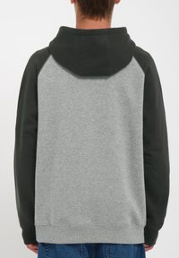 Sudadera gris con mangas raglán de color verde oscuro, capucha con cordón y puños acanalados. Tejido suave con una textura lisa. Sin detalles visibles en la parte delantera.
