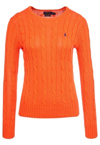 Pomarańczowy sweter z długim rękawem, wykonany w technice warkoczowej, z okrągłym dekoltem i małym, granatowym haftowanym logo po lewej stronie klatki piersiowej.
