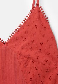 Top senza maniche rosso con ricami floreali, tessuto strutturato e finitura decorativa in pom-pom lungo il girocollo.
