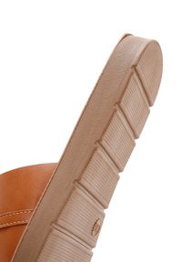 Zapato de cuero marrón claro con suela de goma con estrías verticales, puntera redondeada y un diseño de bajo perfil.
