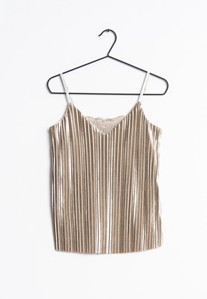 Beige fløjls-camisole med lodrette plisseringer og blonderkant ved udskæringen, hængende på en sort metalbøjle mod en hvid baggrund.