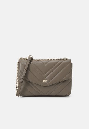 Sac à épaule en cuir matelassé taupe de DKNY avec une chaîne dorée et un logo sur le rabat avant, sur fond blanc.