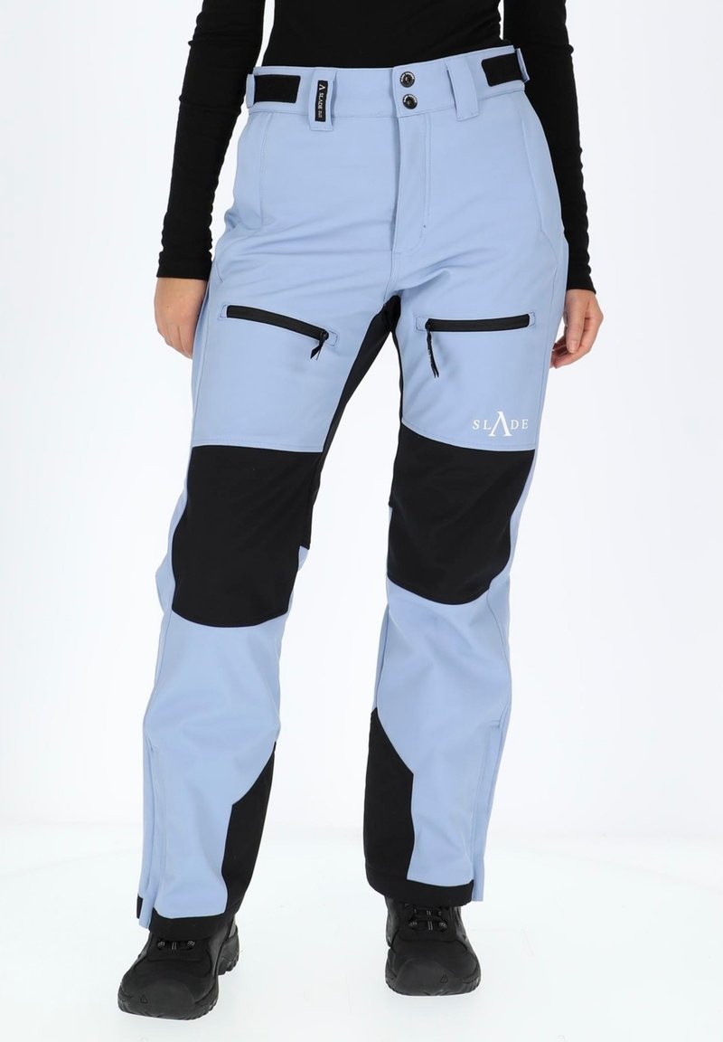 Light blue ski pants with black accents, featuring two front zip pockets and a logo on the thigh. Designed for outdoor activities.