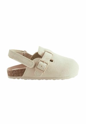 Zueco beige de ante con correa ajustable con hebilla y parte trasera abierta, con suela de corcho y suela exterior de goma texturizada.