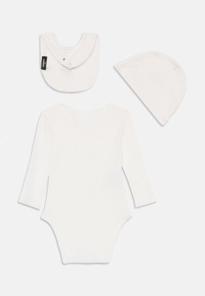 Hvid baby bodystocking i bomuld med lange ærmer, ledsaget af en matchende savlesmæk og hue, alle med bløde teksturer og enkelt design.