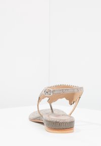 Grå sandal med et tekstureret rem og et subtilt blomstermønster på foden. Har en lille spænde og en flad sål med et trykt design.