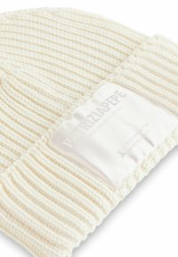 Beanie lavorato a maglia color crema con texture a coste, dotato di un'etichetta in satin bianco con dettagli del marchio in rilievo.