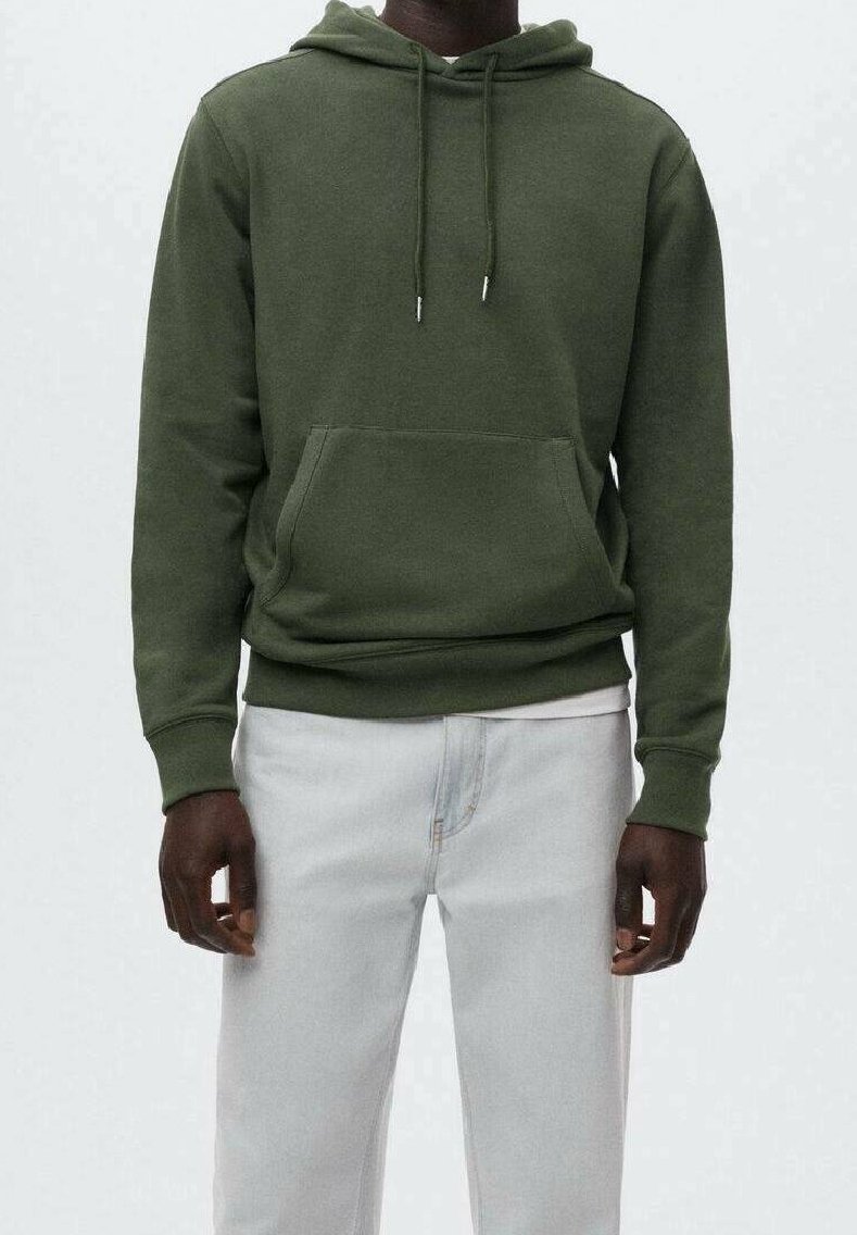 Felpa verde in cotone con tasca frontale, cordini, polsini e orlo a coste. Abbinata a jeans chiari. Design semplice, colore uniforme.