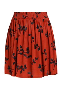 Jupe en tissu rouge avec une taille smockée, ornée de motifs floraux noirs sur toute la surface. Coupe évasée avec une longueur au genou.