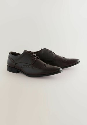 Brune læder sneakers med vinge design, der har perforerede detaljer, en glat overflade og en lav hæl. Snørebåndene er mørkebrune.