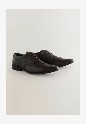 Brune læder sneakers med vinge design, der har perforerede detaljer, en glat overflade og en lav hæl. Snørebåndene er mørkebrune.