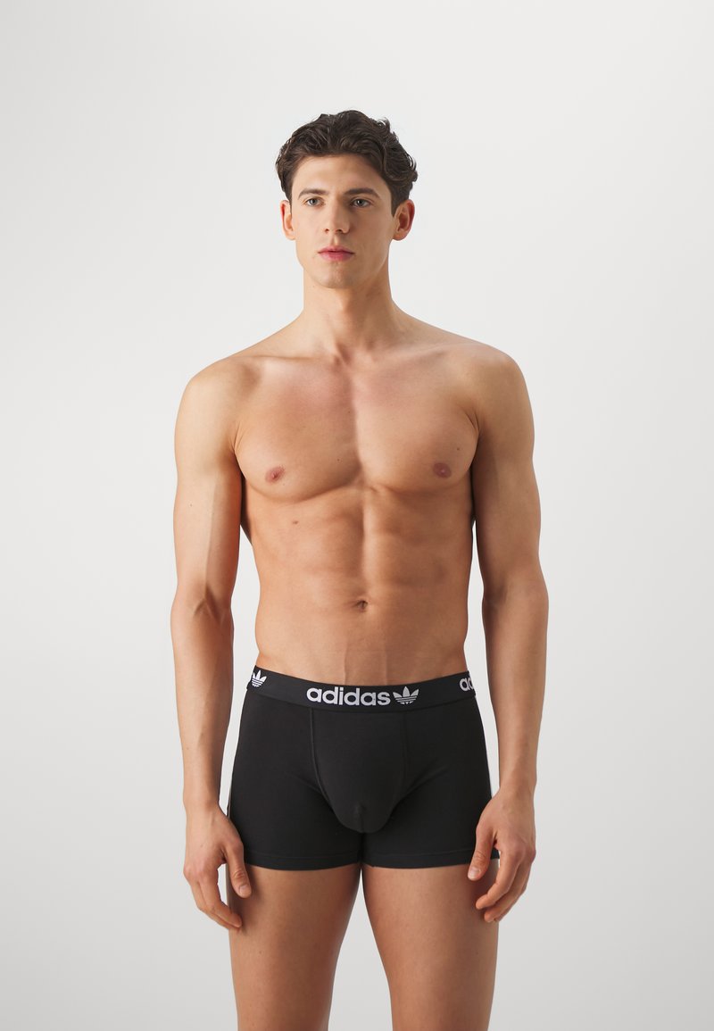 Schwarze Baumwoll-Boxershorts mit einem elastischen Bund, der ein weißes Adidas-Logo und ein Design mit drei Streifen aufweist. Glattes Material, körperbetonter Schnitt.