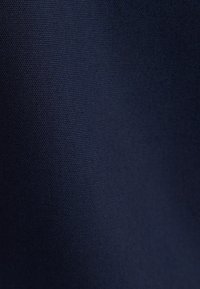 Mørkeblåt stof med fint vævet tekstur, der viser subtilt lysrefleks og glat fald.