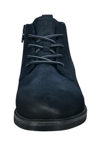 Bottines en daim noir avec un dessus texturé, bout rond et lacets gris contrastants. Comprend une fermeture éclair sur le côté pour un enfilage facile.