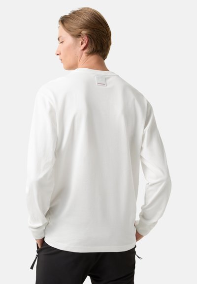 Long-sleeve, white cotton T-shirt with a round neckline and back emblem label; standard cut with slightly textured fabric.