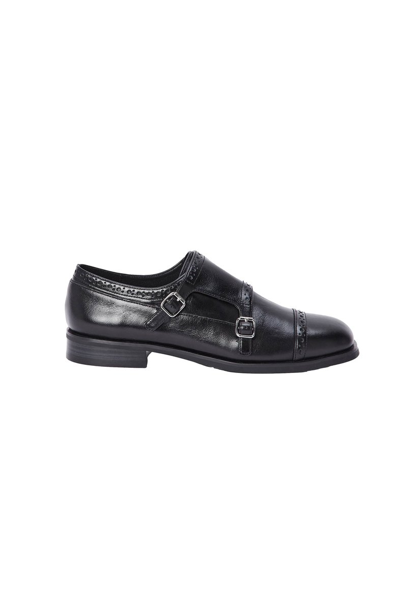 Chaussure en cuir noir avec deux accents de boucle, une couture décorative en haut et un bout arrondi. La semelle est plate et légèrement texturée.