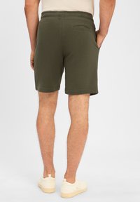 Olivengrüne Shorts aus einem Baumwollmix mit elastischem Bund, Seitentaschen und einer Gesäßtasche. Der Schnitt endet knapp über dem Knie.