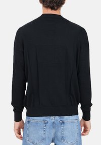 Maglione nero a maglia con scollatura rotonda e maniche lunghe. Presenta una texture liscia e un design aderente con cuciture posteriori e dettagli di cucitura.