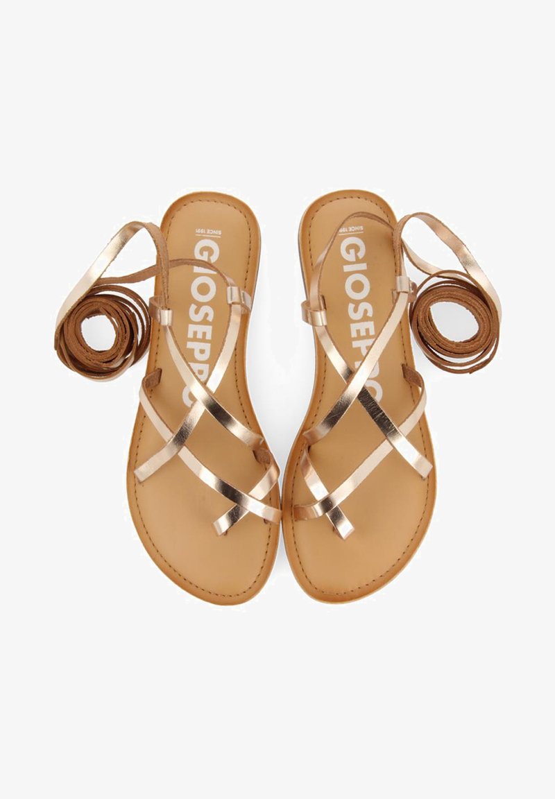 Strappy flat sandals with metallic rose-gold straps, tan footbed, and a minimalist design. Features rolled straps on each side.