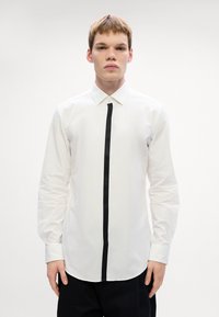 Witte overhemd met lange mouwen, voorzien van een zwarte verticale streep aan de voorkant, met knoopkraag en een aansluitend ontwerp met een gladde textuur.