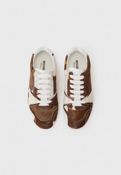 Sneaker marroni e bianchi in pelle di bovino con dettagli in pelle, caratterizzati da lacci bianchi e un design a contrasto. Logo visibile sulla soletta.