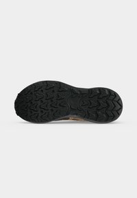 Semelle de chaussure en caoutchouc noir avec un motif de bande de roulement profond et robuste conçu pour l’adhérence sur diverses surfaces, vue par le dessous.