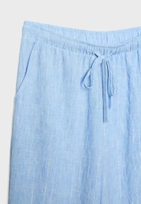Pantalon en lin bleu clair avec taille élastique, cordon de serrage, poches latérales et fines rayures blanches verticales.