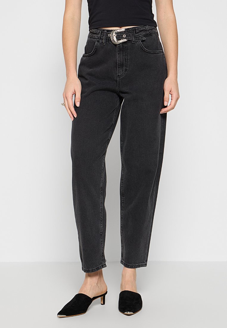 Jeans negros de tiro alto con un corte recto, que cuentan con un cinturón de hebilla plateada, bolsillos frontales y un ligero desvanecimiento para dar textura.
