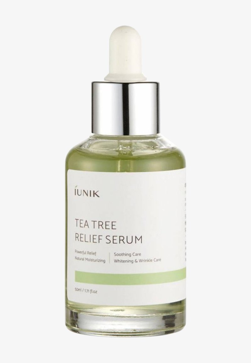 Flacon compte-gouttes en verre transparent avec bouchon argenté étiqueté "IUNIK Tea Tree Relief Serum" contenant un liquide vert clair, 50 ml.