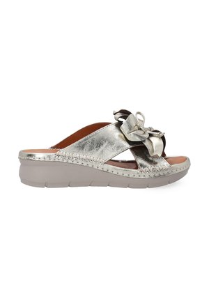 Metallic silver slide sandal with a decorative bow, open-toe design, cushioned footbed, and a chunky, textured sole for stability.