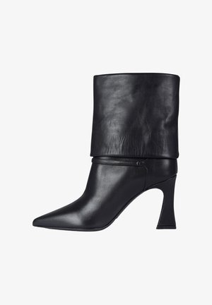 Stivaletto in pelle nera con gambale alto, punta affusolata e tacco alto sagomato. Texture liscia con hardware minimale.