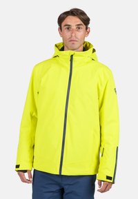 Chaqueta impermeable amarilla brillante con capucha, que cuenta con un cierre frontal y bolsillos laterales. Textura suave con acentos en azul marino en contraste.