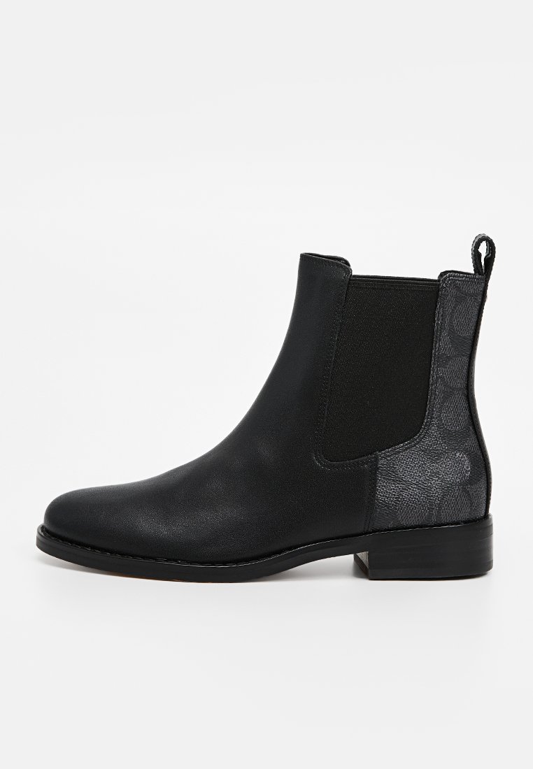 Bottines Chelsea noires avec une tige en cuir lisse, des panneaux latéraux élastiques et un motif texturé noir en accent sur le talon. Talon bas empilé.