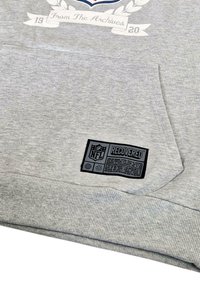 Gray sweatshirt featuring a kangaroo pocket and ribbed cuffs. Includes a black NFL "RECOVERED" label with care instructions and logos.