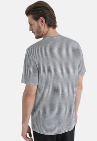 Raidallinen t-paita harmaana ja mustana, lyhyet hihat, pyöreä kaula-aukko, pehmeä kangas, hieman pidempi takahelma, rento istuvuus.