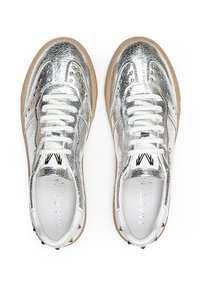 Zapatillas metálicas plateadas con un upper de cuero texturizado, cordones blancos y una suela beige. Presenta acentos de tachuelas a lo largo de los costados.