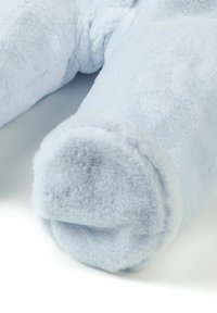 Manta de peluche suave y de un azul claro, con una textura lisa, que presenta bordes redondeados y una apariencia acogedora. Sin patrones visibles ni detalles de hardware.