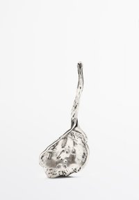 Metall-Schöpflöffel mit einem schlanken, länglichen Griff und einer strukturierten, unregelmäßigen Schale. Silberne Oberfläche mit sichtbaren Handwerksdetails und einer reflektierenden Fläche.