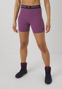 Violetinės sportinės šortai su juodu juosmeniu, ant kurio yra Venum logotipas, suprojektuoti su šonine kišenė ir pagaminti iš elastingos medžiagos.