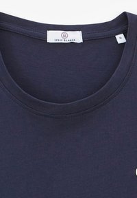 T-shirt bleu marine avec un col rond et des manches courtes. Dispose d'une petite étiquette logo sur la zone de la poitrine. Fabriqué en tissu doux. Taille : M.