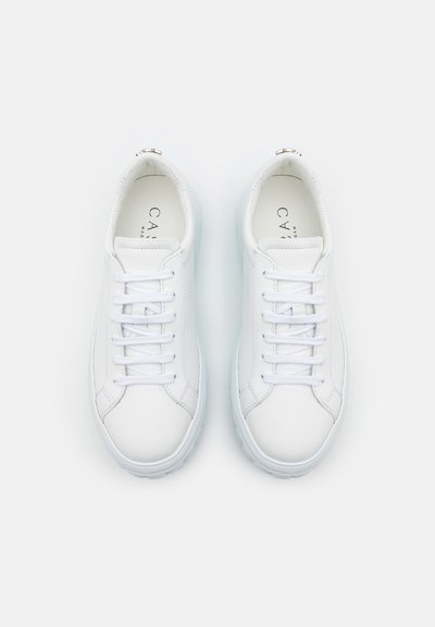Baskets blanches en cuir avec bout rond, lacets plats et un col légèrement rembourré ; semelle en caoutchouc avec des accents bleus subtils. Nom de la marque visible à l'intérieur.