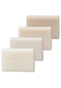 Four rectangular bars of soap in varying shades of light cream and beige. Textured surface with embossed branding, labeled "Vegan" and "Hafermilch."